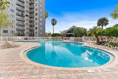a swimming pool in front of a building at 6165 Carrier Drive 1001 in Orlando