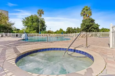 a hot tub in a courtyard with palm trees at 6165 Carrier Drive 1001 in Orlando