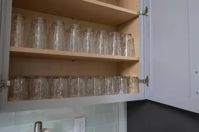 a bunch of glasses sitting on a shelf in a kitchen at EPIC STYLISh retreat With Free water park near Disney in Kissimmee