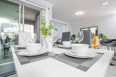 a white table with plates and wine glasses on it at EPIC STYLISh retreat With Free water park near Disney in Kissimmee