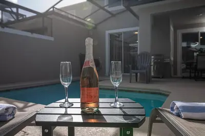 a bottle of wine sitting on a table with two glasses at EPIC STYLISh retreat With Free water park near Disney in Kissimmee