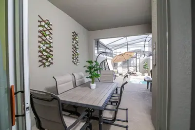 a dining room with a table and chairs and an umbrella at EPIC STYLISh retreat With Free water park near Disney in Kissimmee