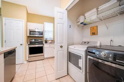 a kitchen with a washer and dryer at Epic Arty Retreat near Disney in Kissimmee