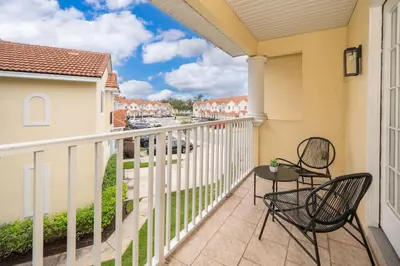 a balcony with two chairs and a table at Epic Arty Retreat near Disney in Kissimmee