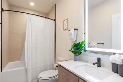a bathroom with a sink and a toilet and a mirror at Modern Townhouse Heated Pool Disney Orlando 17244 in Orlando