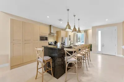 a kitchen with a black counter and bar chairs at Luxury 4BR Townhouse Next to Disney Orlando 3201 in Orlando