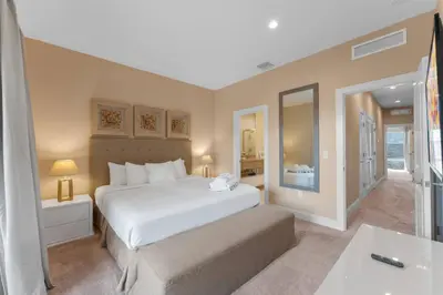 a bedroom with a large white bed and a bathroom at Luxury 4BR Townhouse Next to Disney Orlando 3175 in Orlando