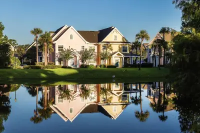 a house with a reflection in the water at Runaway Beach Club Resort Condo Apt Disney 15103 in Kissimmee