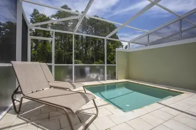 a room with a chair and a swimming pool at Modern Townhouse Heated Pool Disney Orlando 1500R in Orlando