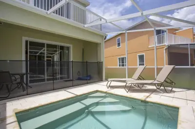 a patio with two chairs and a swimming pool at Modern Townhouse Heated Pool Disney Orlando 1500R in Orlando