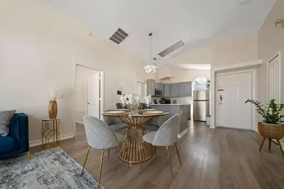 a kitchen and living room with a table and chairs at Vacation Oasis Home with Private Pool and Grill 8615 in Kissimmee