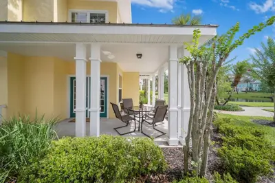 a home with a porch with chairs and a table at Runaway Beach Club Resort Condo Apt Disney 6102 in Kissimmee
