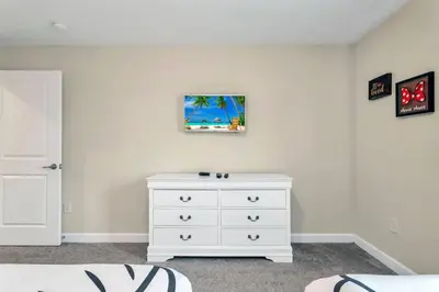 a bedroom with a white dresser and a painting on the wall at Storey Lake Resort Townhouse near Disney Orlando 4847 in Kissimmee