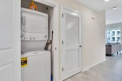 a kitchen with a washer and dryer in a room at Modern Storey Lake Resort Disney Orlando 3150-303 in Kissimmee
