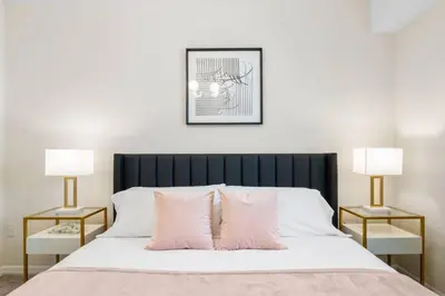 a bedroom with a bed with pink pillows and two lamps at Modern Storey Lake Resort Disney Orlando 3171-206 in Kissimmee