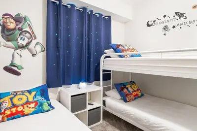 a bedroom with two bunk beds and a blue curtain at Modern Storey Lake Resort Disney Orlando 3161-107 in Kissimmee