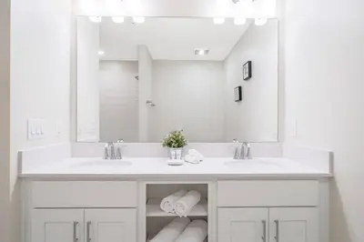 a bathroom with two sinks and a large mirror at Modern Storey Lake Resort Disney Orlando 3161-107 in Kissimmee