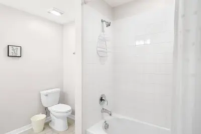 a white bathroom with a toilet and a shower at Modern Storey Lake Resort Disney Orlando 3161-107 in Kissimmee