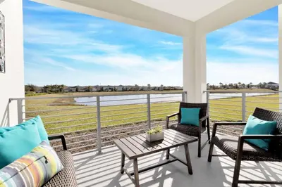a balcony with chairs and a table and a view of a field at Modern Storey Lake Resort Disney Orlando 3191-106 in Kissimmee