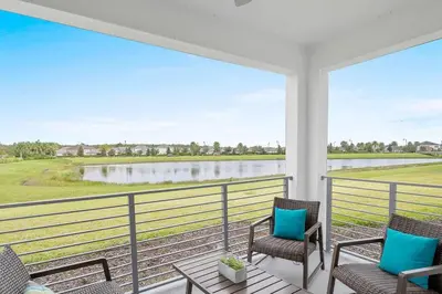 a porch with chairs and a view of a lake at Modern Storey Lake Resort Disney Orlando 3191-106 in Kissimmee