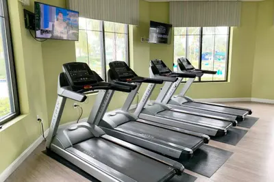 a row of treadmills in a gym with windows at Modern Storey Lake Resort Disney Orlando 3191-106 in Kissimmee