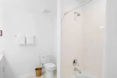 a white bathroom with a toilet and a shower at Modern Storey Lake Resort Disney Orlando 3191-106 in Kissimmee
