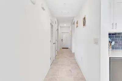 a hallway with white walls and a tile floor at Modern Storey Lake Resort Disney Orlando 3191-106 in Kissimmee
