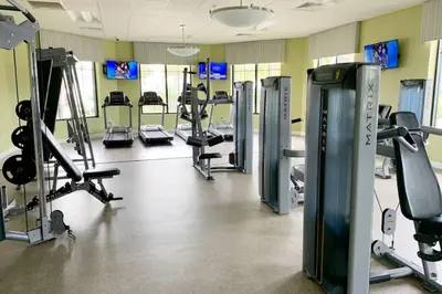 a gym with several treadmills and cardio machines at Modern Boho Storey Lake Resort Disney 3150-106 in Kissimmee