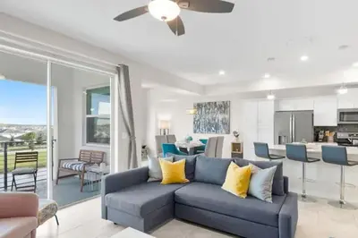 a living room with a blue couch and a kitchen at Modern Storey Lake Resort Disney Orlando 3161-401 in Kissimmee