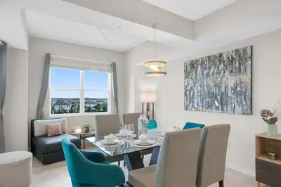 a living room with a dining room table and chairs at Modern Storey Lake Resort Disney Orlando 3161-401 in Kissimmee