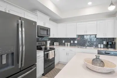 a kitchen with white cabinets and stainless steel appliances at Modern Storey Lake Resort Disney Orlando 3161-401 in Kissimmee
