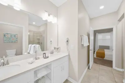 a white bathroom with two sinks and a large mirror at Modern Storey Lake Resort Disney Orlando 3121-402 in Kissimmee