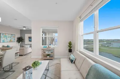 a living room with a couch and a large window at Modern Storey Lake Resort Disney Orlando 3121-402 in Kissimmee