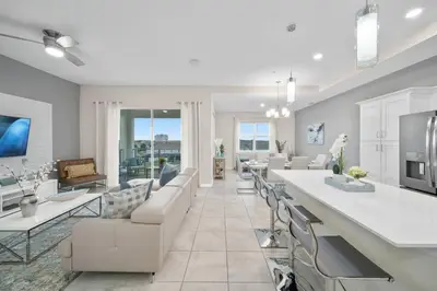a kitchen and living room with a couch and chairs at Modern Storey Lake Resort Disney Orlando 3121-402 in Kissimmee