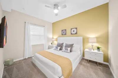 a bedroom with a large white bed and a window at Modern Storey Lake Resort Disney Orlando 3121-402 in Kissimmee