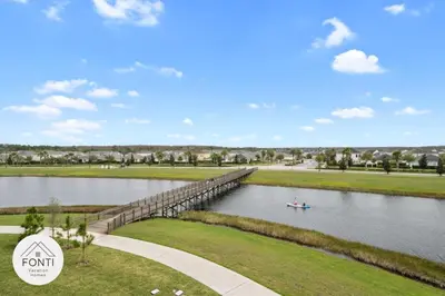 a boat on a river with a bridge at Brand New Lakeview Storey Lake Resort Disney 3121-103 in Kissimmee