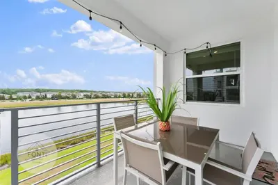 a dining room with a table and chairs on a balcony at Modern Storey Lake Resort Disney Orlando 3171-302 in Kissimmee