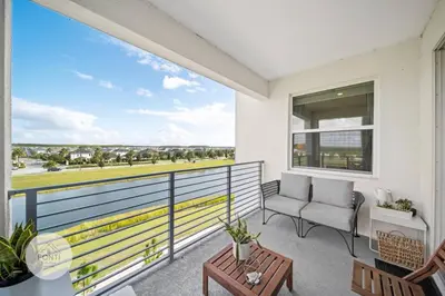 a balcony with a couch and a view of the ocean at Modern Storey Lake Resort Disney Orlando 3161-402 in Kissimmee