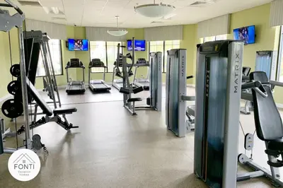 a gym with treadmills and machines in a room at Modern Storey Lake Resort Disney Orlando 3161-402 in Kissimmee