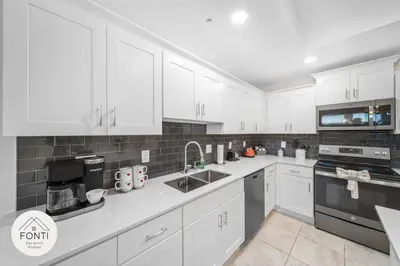 a kitchen with white cabinets and black appliances at Modern Storey Lake Resort Disney Orlando 3171-301 in Kissimmee