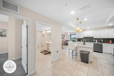 a kitchen and living room with white cabinets and a table at Modern Storey Lake Resort Disney Orlando 3171-301 in Kissimmee