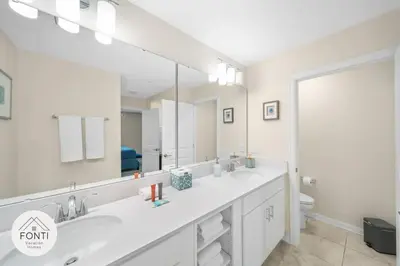 a bathroom with two sinks and a large mirror at Modern Storey Lake Resort Disney Orlando 3171-301 in Kissimmee