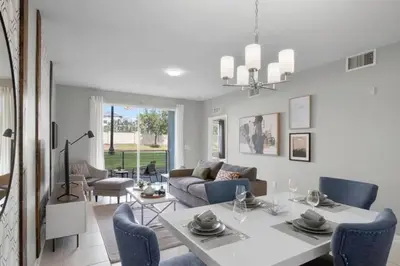 a living room with a white table and blue chairs at Modern Storey Lake Resort Disney Orlando 4741-104 in Kissimmee