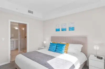 a white bedroom with a bed and a bathroom at Modern Storey Lake Resort Disney Orlando 3141-105 in Kissimmee