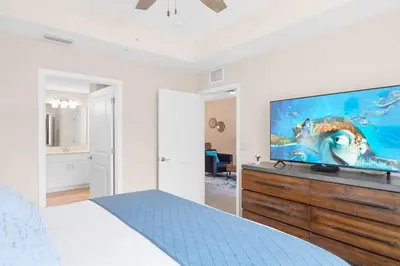 a bedroom with a large flat screen tv on a dresser at Modern Storey Lake Resort Disney Orlando 3180-104 in Kissimmee