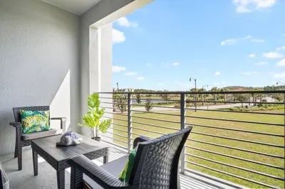 a balcony with a table and chairs and a view of a baseball field at Modern Storey Lake Resort Disney Orlando 3191-204 in Kissimmee