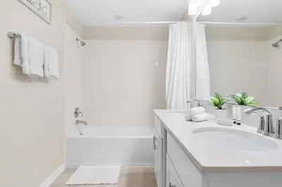 a white bathroom with a sink and a bath tub at Modern Storey Lake Resort Disney Orlando 3161-305 in Kissimmee