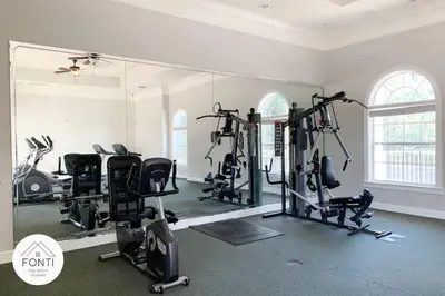 a gym with several tread machines and a large mirror at Secret Lake Resort 2BR Condo Apt Disney 3176-301 in Kissimmee