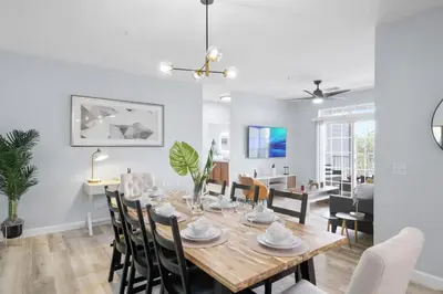 a dining room and living room with a table and chairs at Secret Lake Resort 3BR Apt Disney Orlando 3175-205 in Kissimmee