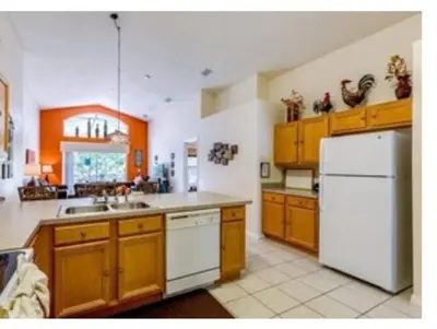 a kitchen with wooden cabinets and a white refrigerator at Make your dreams really come true in Kissimmee